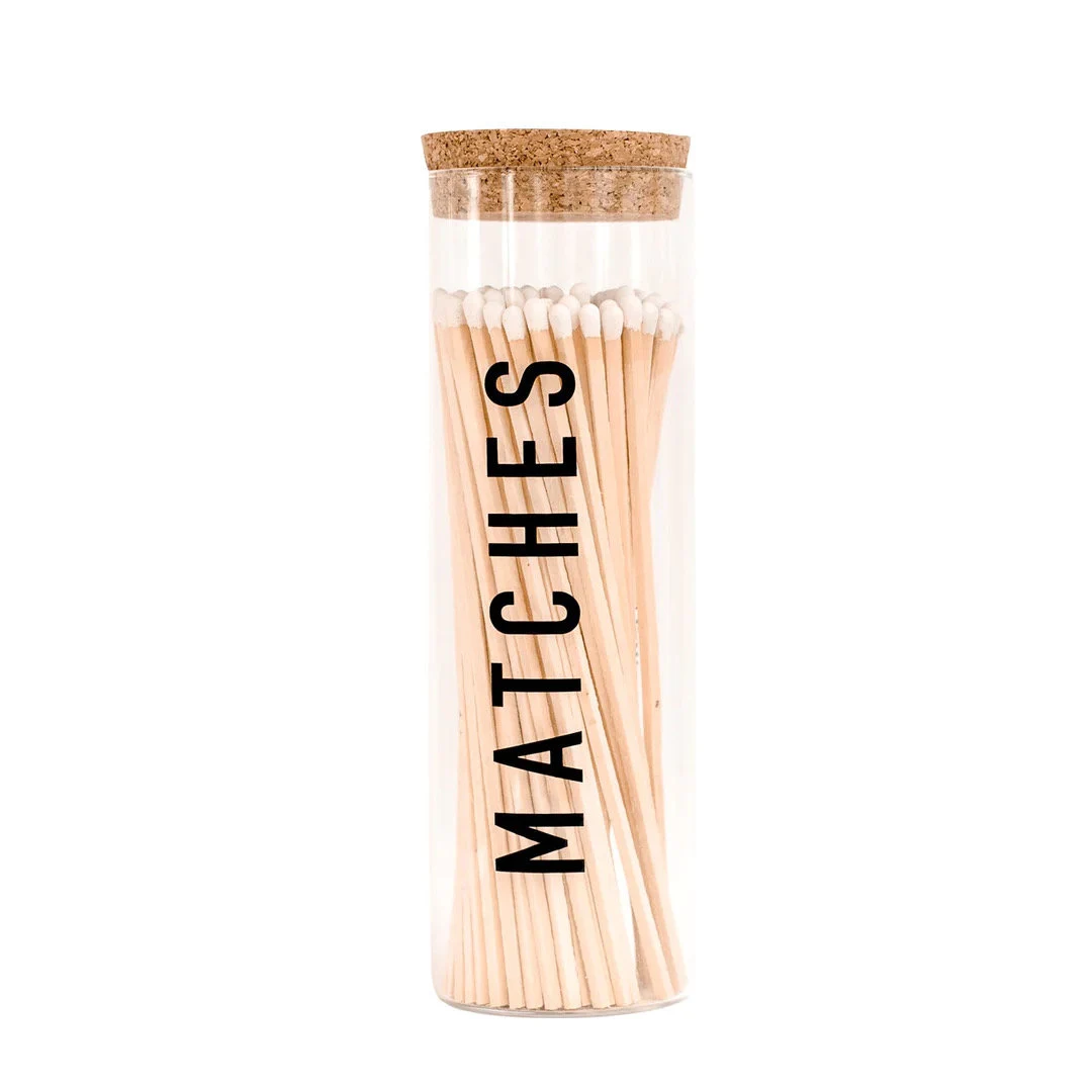 A glass tube with matches on top of it.